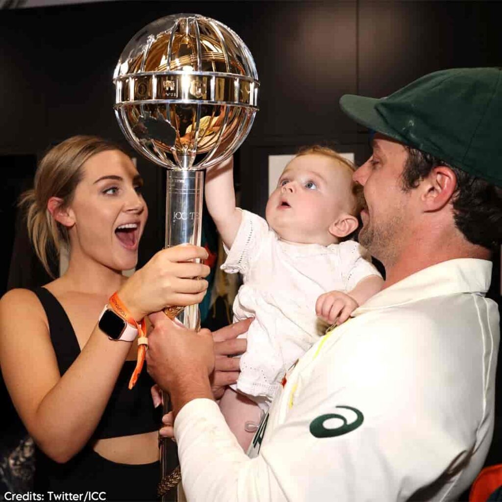 Image of Travis Head with his wife and child holding the WTC 2023 Trophy where India lost against Australia by 209 runs
